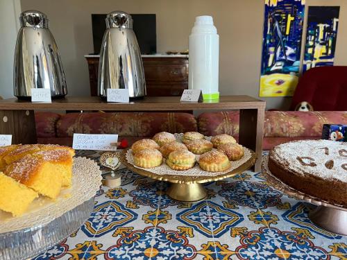 a table topped with different types of cakes and pastries at Cento Giorni B&B Costa Paestum in Capaccio-Paestum