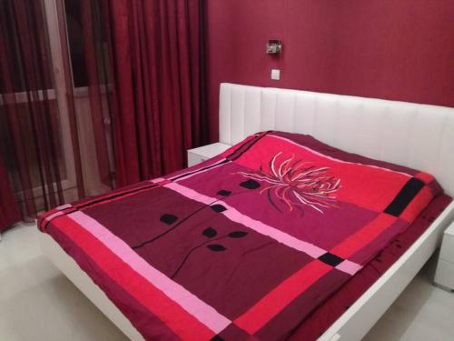 a bed with a red and pink blanket on it at Top luxury apartment, great location in Sofia