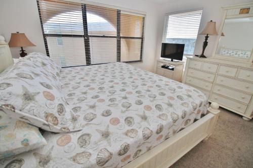 a bedroom with a bed and a dresser and a television at Ocean Club North C208 in New Smyrna Beach