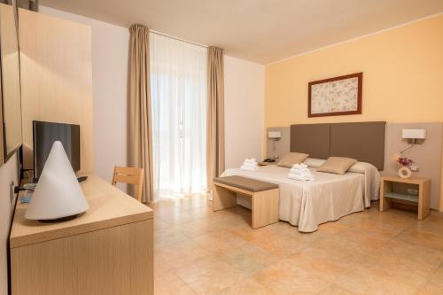 a hotel room with a bed and a television at Hotel Degli Aranci in Vieste