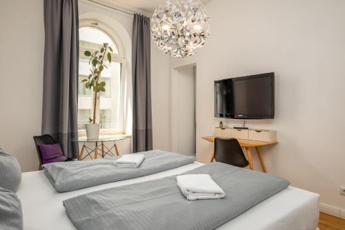 a bedroom with two beds and a flat screen tv at Apartments an der Arena Leipzig in Leipzig