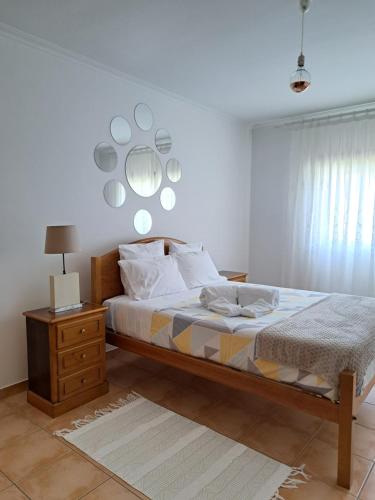 een slaapkamer met een bed en een spiegel aan de muur bij Camarção Violante in Foz do Arelho