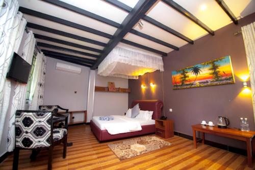 1 dormitorio con 1 cama, mesa y sillas en Kijiji Beach Resort, en Dar es Salaam