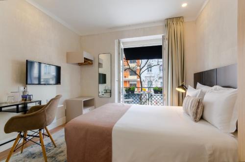 リスボンにあるLX51 Studios & Suites by APT IINのベッド、デスク、窓が備わるホテルルームです。