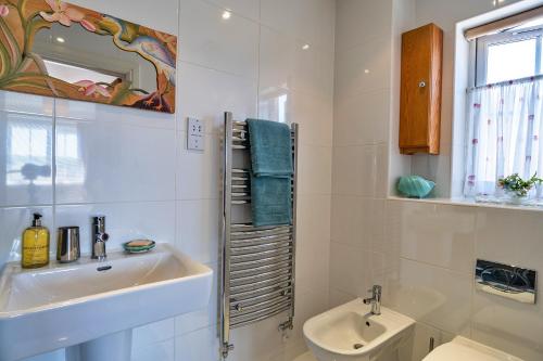 een witte badkamer met een wastafel en een toilet bij Finest Retreats - Seascape in Teignmouth