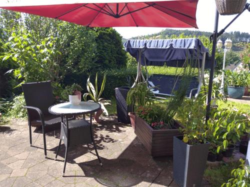 - une table et des chaises sous un parasol dans le jardin dans l'établissement Ferienwohnung Pentagono, à Engelskirchen