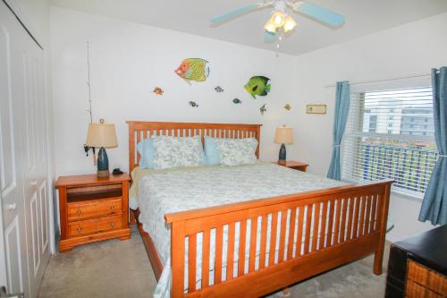 1 dormitorio con cama de madera y ventana en Oceanwalk 12-404, en New Smyrna Beach