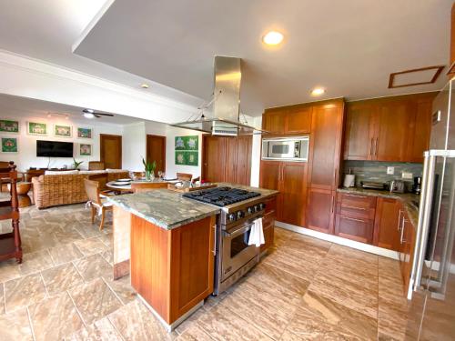 a kitchen with wooden cabinets and a stove top oven at Xeliter Balcones del Atlantico - Las Terrenas in Las Terrenas