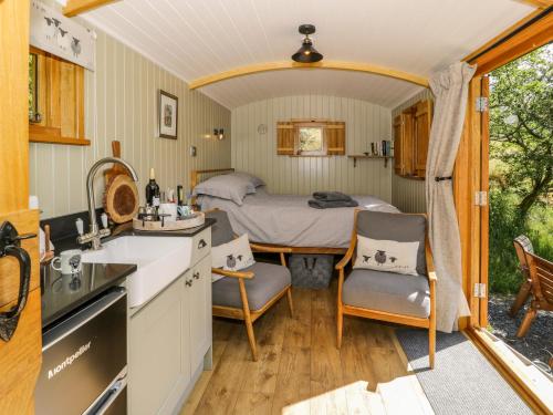 een keuken en een slaapkamer met een bed in een kamer bij Moelfre - Shepherds Hut in Llanbedr