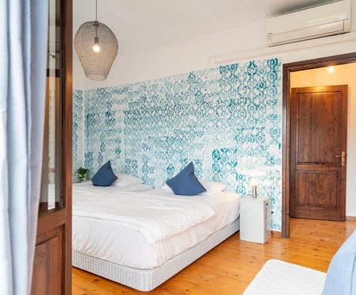 1 dormitorio con 1 cama con papel pintado azul y blanco en Casa Ortensia: rustico ristrutturato in pietra, en Rive dʼArcano
