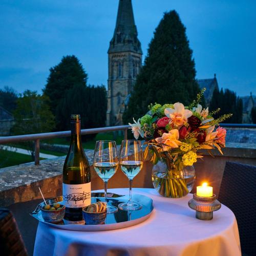 a table with two glasses of wine and a candle at Matfen Hall Hotel, Golf & Spa in Matfen