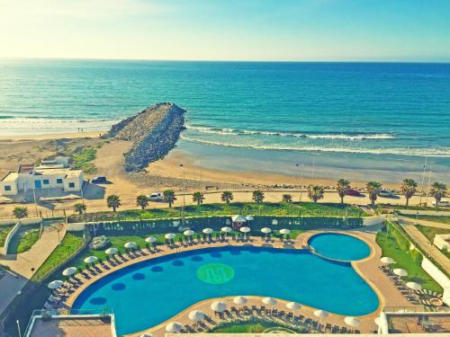 an aerial view of a resort with a pool and the beach at Grand Mogador Sea View & Spa in Tangier