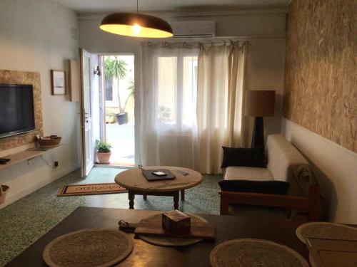 un salon avec un canapé et une table dans l'établissement Appartement au coeur du village pour deux personnes, à Lespignan