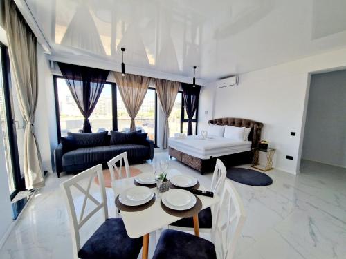 a living room with a bed and a table and chairs at Studio Armsea Mamaia Nord in Mamaia