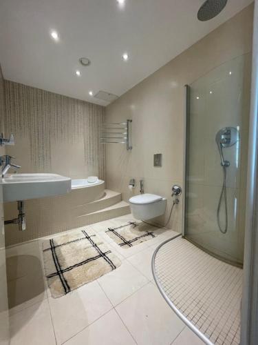 y baño con ducha, aseo y lavamanos. en Design apartment, en Klaipėda
