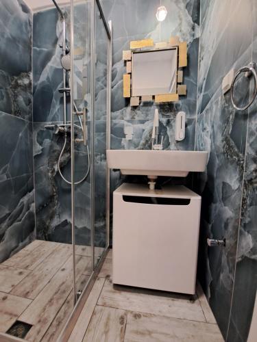 La salle de bains est pourvue d'un lavabo et d'une douche. dans l'établissement Gala Premium, à Potidée