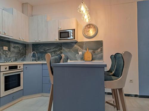 a kitchen with a counter with chairs and a clock on the wall at Gala Premium in Nea Potidaea