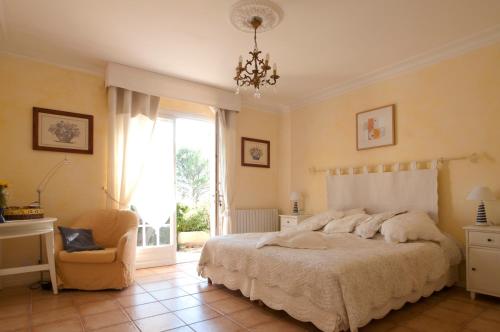 1 dormitorio con 1 cama, 1 silla y 1 ventana en Residence "Villa Catherine", en Flayosc