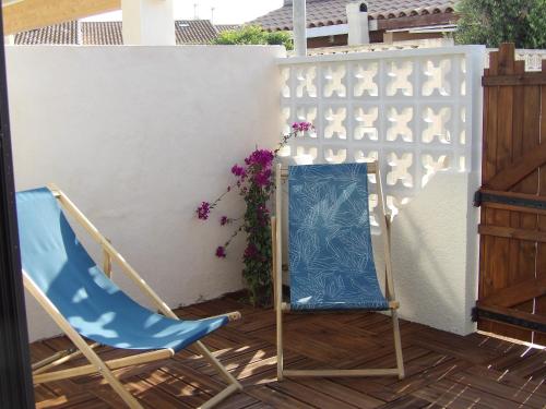 een blauwe stoel naast een wit hek bij Bleu Soleil in Gruissan