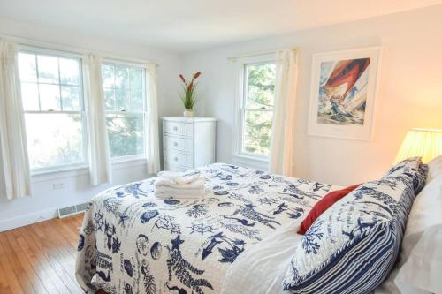 - une chambre avec un lit bleu et blanc et des fenêtres dans l'établissement Stunning Bay Views by Beach Dog Friendly, à Eastham