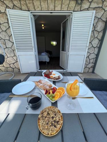- une table avec des assiettes de nourriture et des fruits dans l'établissement Sun&Fun Studio Apartment, à Hvar