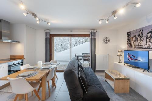 a living room with a couch and a table at Les Loges Blanches - Apt B103 - BO Immobilier - Châtel - Multipass été 2025 en option 3e par jour par personne in Châtel