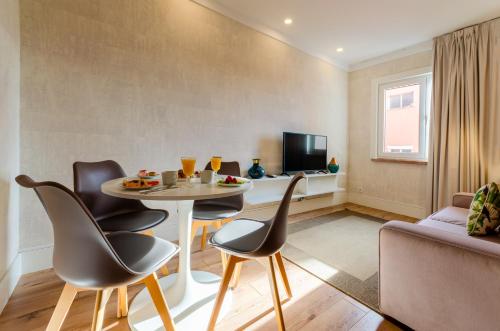 ein Wohnzimmer mit einem Tisch und Stühlen sowie einem TV in der Unterkunft LX51 Studios & Suites by APT IIN in Lissabon