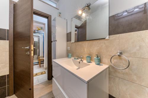 bagno con lavandino e specchio di Casa vacanze vicino a Otranto a Giurdignano