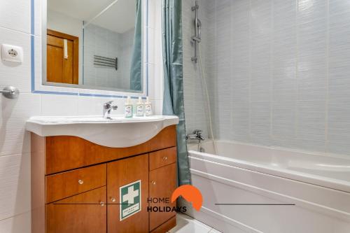 Un baño con lavabo, bañera y espejo. en #172 Falésia Beach by Home Holidays, en Albufeira