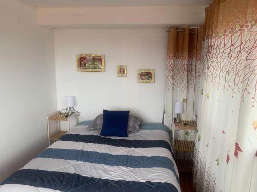 a small bedroom with a bed with a blue pillow at Summit Viewpoint House San Blas in Cusco
