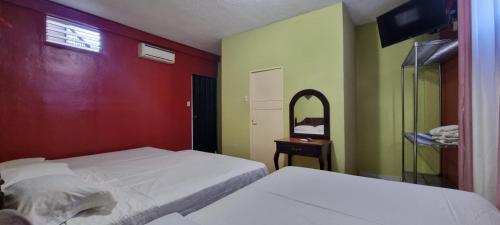 a bedroom with two beds and a mirror at Hotel Los Andes Tegucigalpa in Tegucigalpa