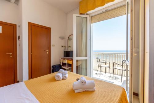 pokój hotelowy z łóżkiem z ręcznikami w obiekcie Hotel Carnaby w Rimini