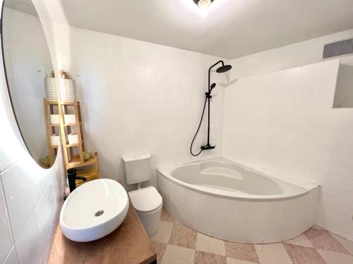 ein weißes Bad mit einer Badewanne und einem WC in der Unterkunft JUMA in Jesenice