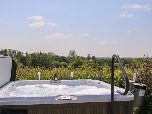 a bath tub with a bottle of champagne in it at Groomes Country House in Bordon