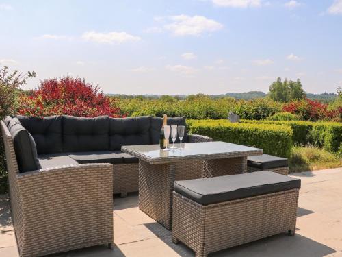 a patio with a couch and a table and chairs at Groomes Country House in Bordon