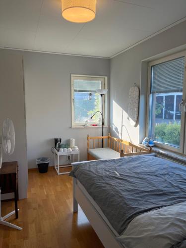 a bedroom with a large bed and two windows at A room in a villa close to Arlanda Airport in Stockholm