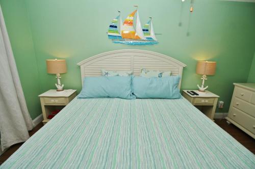 1 dormitorio con 1 cama grande con almohadas azules en Sea Coast Gardens II 117, en New Smyrna Beach