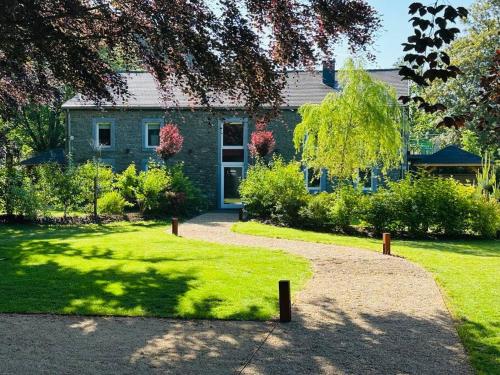 a house with a pathway in front of a yard at Jacuzzi - Sauna - BBq - Jardin - Garden Lodge - Myosotis in Olne