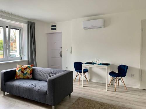 ein Wohnzimmer mit einem Sofa und einem Tisch mit Stühlen in der Unterkunft Interno Casa in Sopron