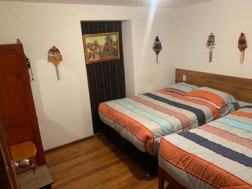 a bedroom with two beds and a door in it at Summit Viewpoint House San Blas in Cusco