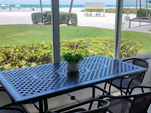 une table bleue avec une plante en pot assise sur une terrasse couverte dans l'établissement Island House Beach Resort 2S, à Siesta Key
