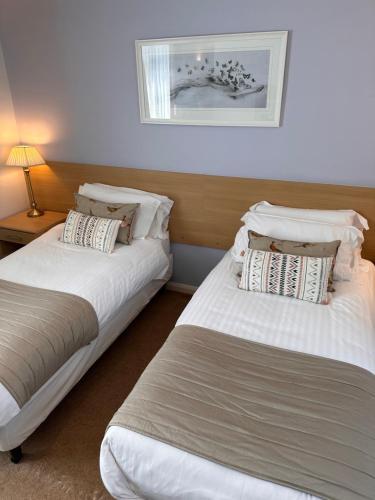 two beds sitting next to each other in a room at Horseshoes cafe and lodge in Welbourn