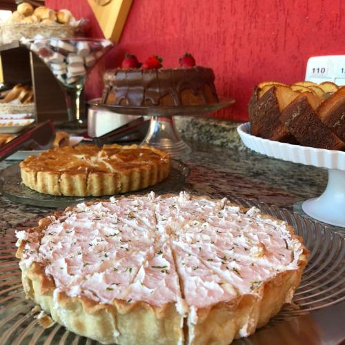 a table topped with pies and cakes on plates at Pousada Jordão in Campos do Jordão
