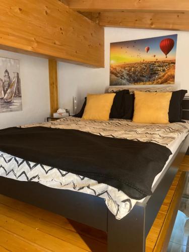 a large bed in a room with wooden ceilings at Les balcons du Rhône in Daillon