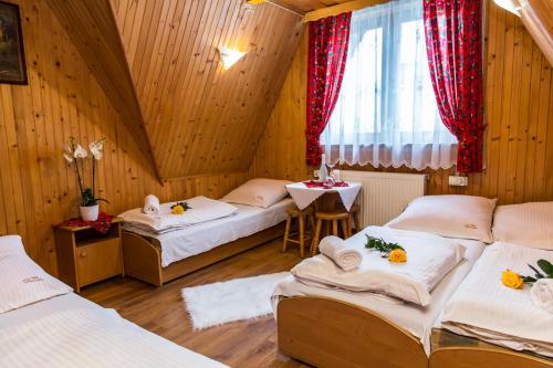 um quarto com três camas e uma janela em Willa Danuśka em Zakopane