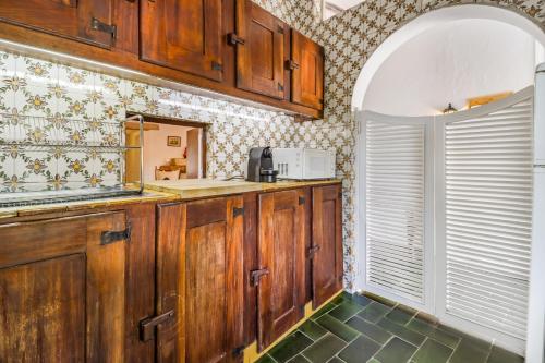 una cocina con armarios de madera y una ventana en Casa do Mar - Golf Jamor en Oeiras