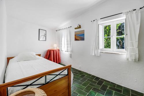 1 dormitorio con cama y ventana en Casa do Mar - Golf Jamor, en Oeiras