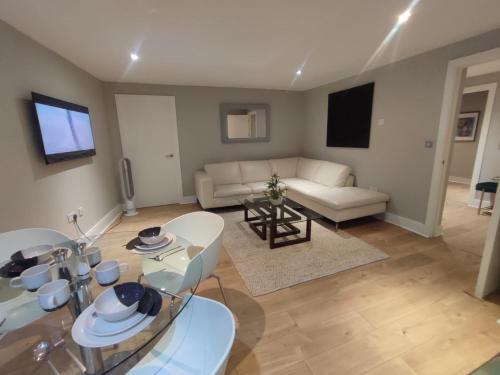 a living room with a table and a couch at 3BR Apt Near Excel, O2 & City Airport! in London