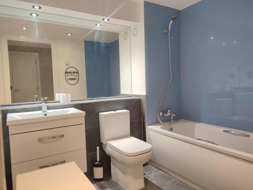 a bathroom with a toilet and a tub and a sink at 3BR Apt Near Excel, O2 & City Airport! in London