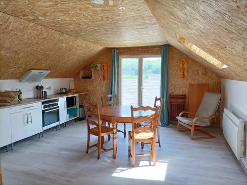 une cuisine avec une table et des chaises dans une pièce dans l'établissement Appartement proche des lacs, à Laffrey